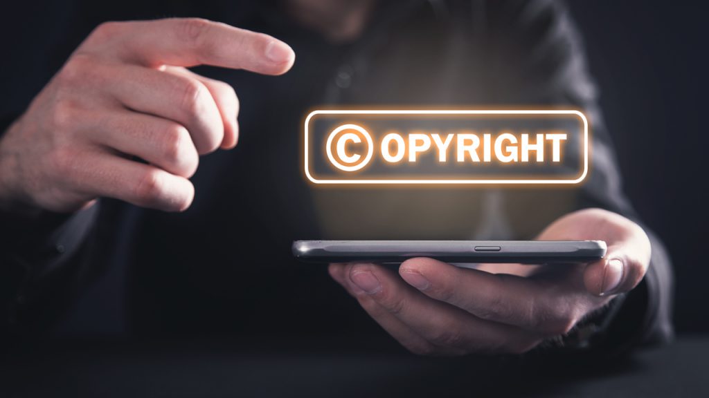 The word Copyright being projected from a smartphone.