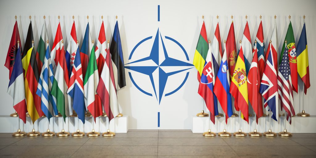 NATO logo flanked by the flags of member states.