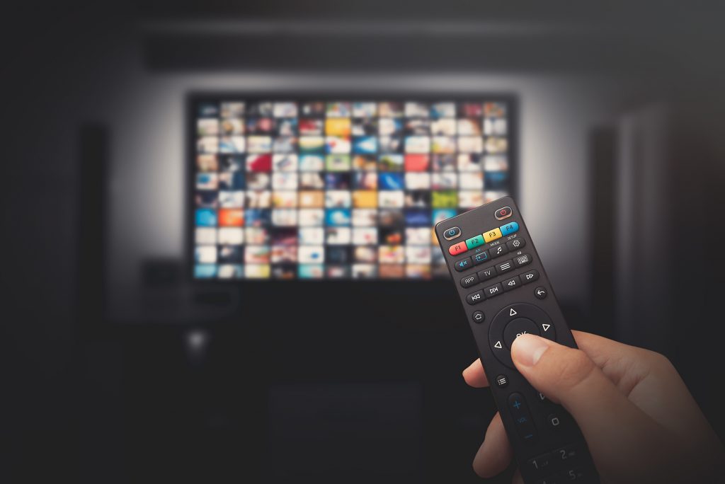 A remote control selects from a variety of options on a television.