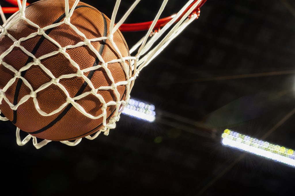 A basketball going through a net.