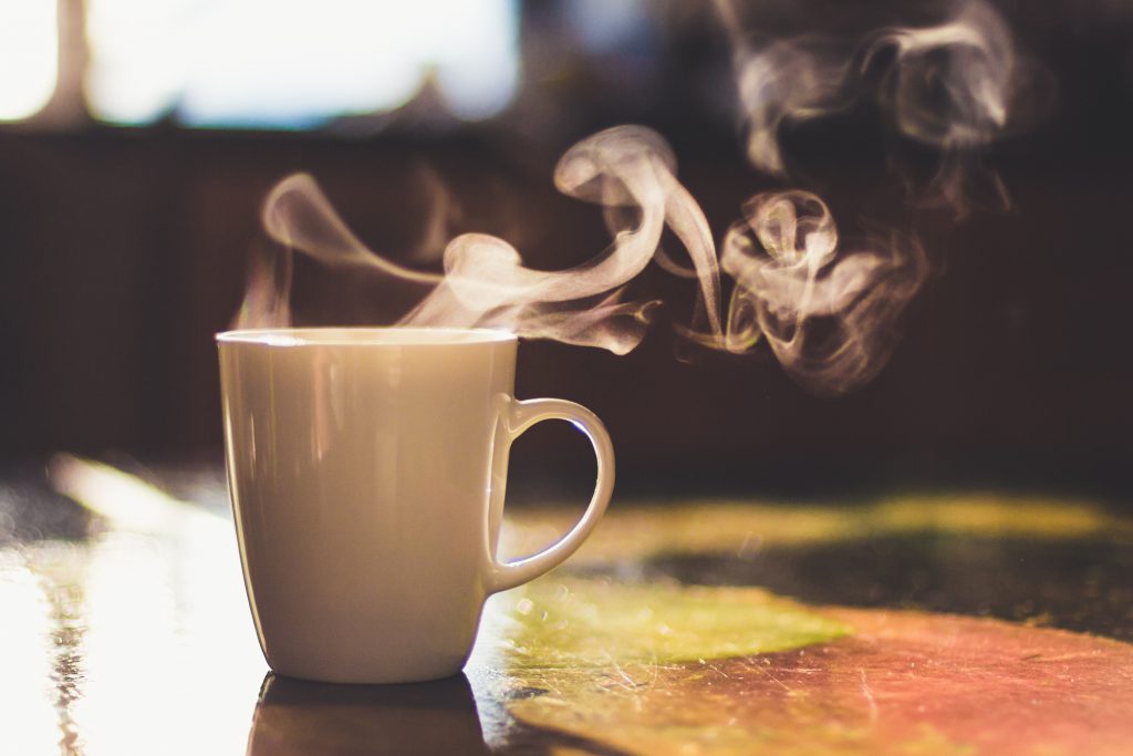 A steaming cup of coffee.