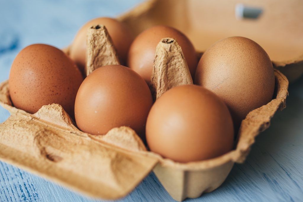 Six brown eggs in an egg carton.