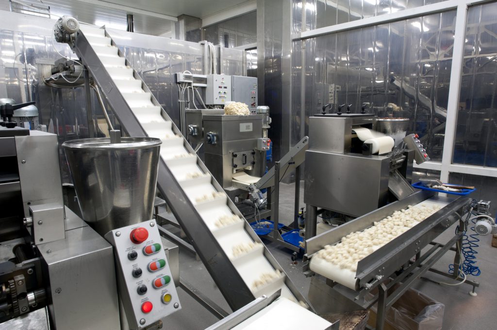 Food making its way along a conveyor belt in a factory.