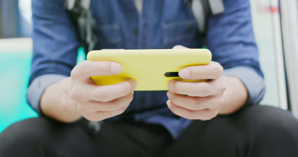 A man playing mobile games on his cell phone.